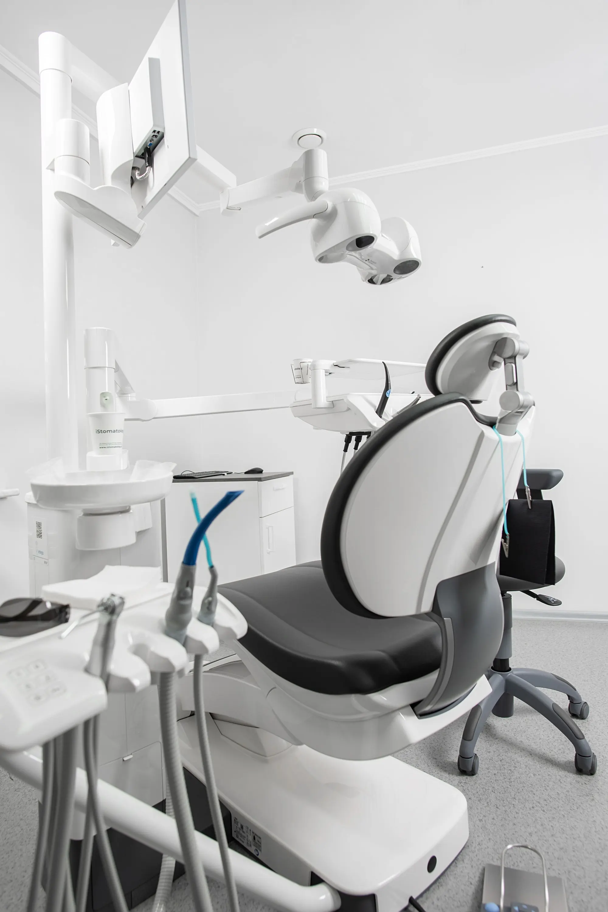 A bright treatment room with a dental chair and instruments