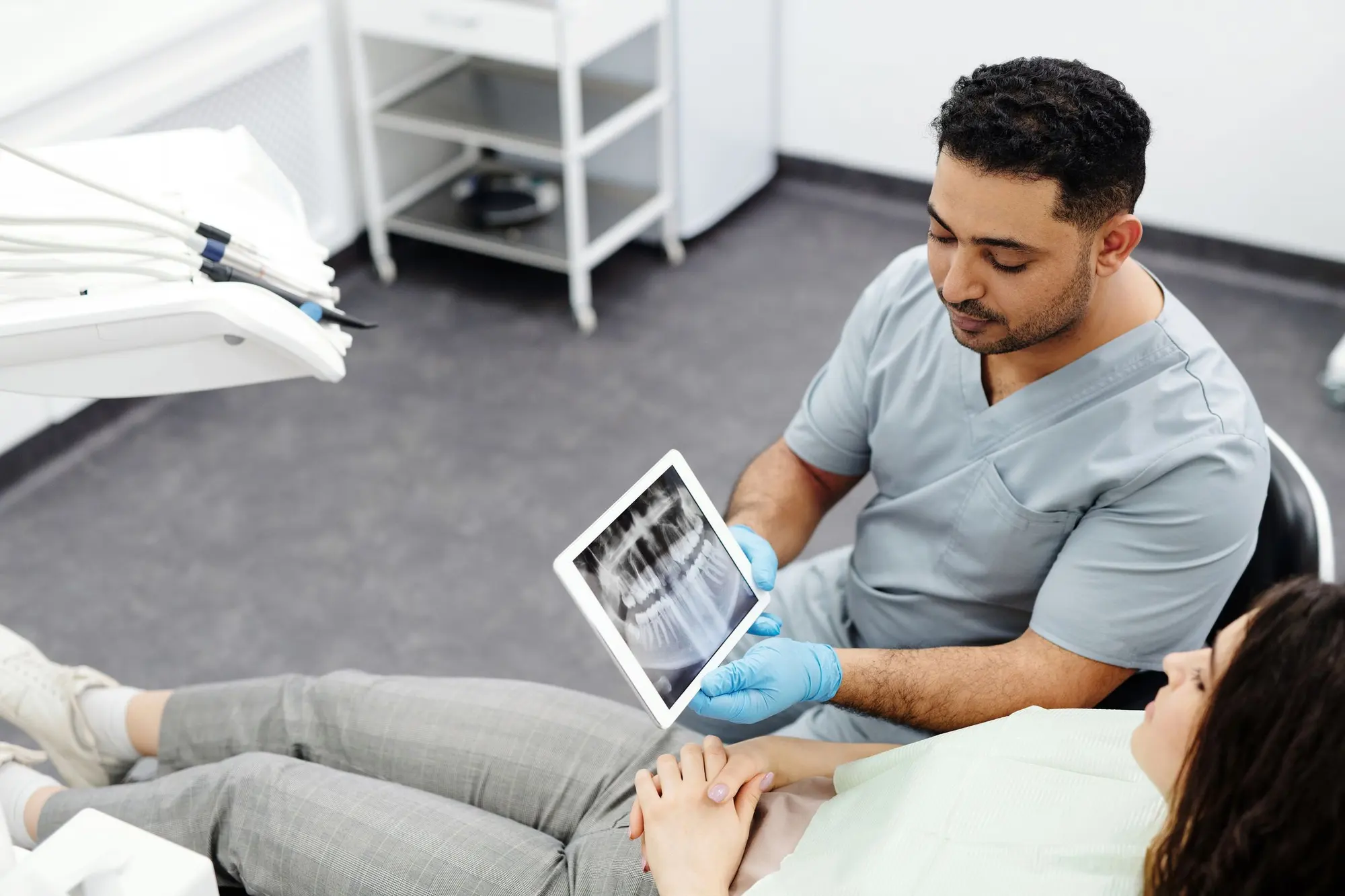 A dentist showing a patient an x-ray on a tablet
